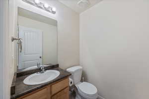 Half bathroom with vanity and toilet