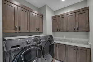 Washroom featuring washing machine and clothes dryer and cabinet space