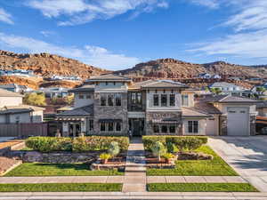 Prairie-style house featuring stone siding, concrete driveway, a mountain view, and an attached garage