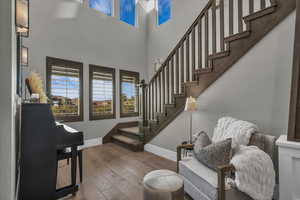 Stairway featuring hardwood / wood-style floors and a high ceiling