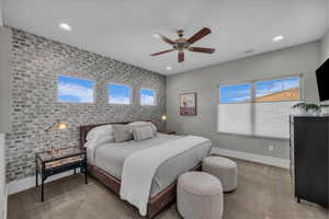 Bedroom with brick wall, an accent wall, light carpet, ceiling fan, and recessed lighting