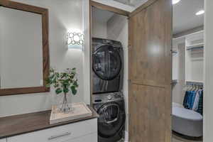 Laundry area with stacked washer and clothes dryer