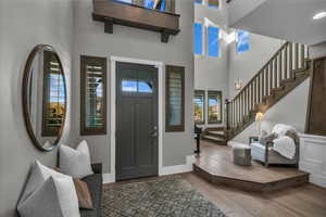 Entrance foyer featuring hardwood / wood-style flooring, stairway, and a towering ceiling