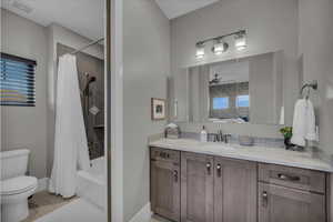 Bathroom featuring shower / tub combo with curtain, vanity, and ceiling fan