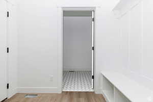 Mudroom featuring light wood finished floors and baseboards