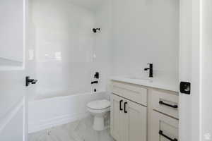 Full bath featuring vanity, shower / bath combination, and light marble finish flooring