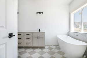 Bathroom with light flooring, vanity, and a freestanding bath