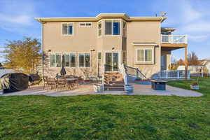 Back of property with a patio, an outdoor fire pit, and stucco siding