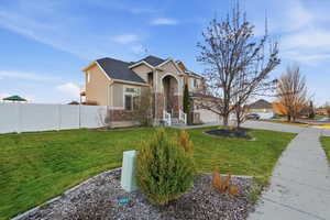 View of front of property with stucco siding, driveway, a garage, and brick siding