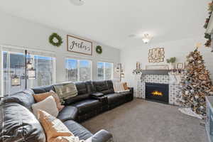 Carpeted living area featuring a tile fireplace and wooden walls