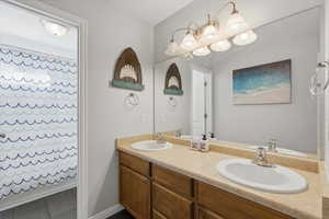 Full bathroom with double vanity and shower / tub combo with curtain