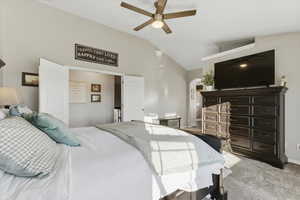 Bedroom with light carpet, lofted ceiling, and ceiling fan