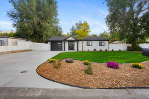 View of front of home with concrete driveway, oil tank, a gate, a garage, and roof with shingles