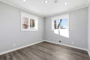 Empty room featuring wood finished floors, healthy amount of natural light, ornamental molding, and recessed lighting