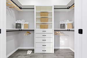 Walk in closet with light wood finished floors