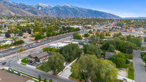 Aerial perspective of suburban area featuring a mountainous background and a highway