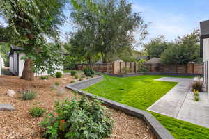 Fenced backyard featuring an outbuilding