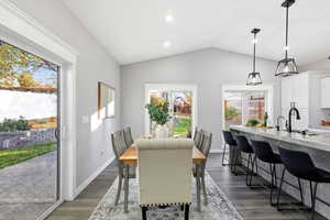 Dining area featuring lofted ceiling, dark wood-style flooring, and recessed lighting