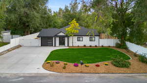 View of front of property featuring a fenced backyard, roof with shingles, driveway, a gate, and an attached garage