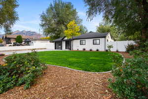 View of front of property with a fenced backyard, board and batten siding, a mountain view, concrete driveway, and a garage
