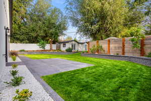 Fenced backyard featuring an outdoor structure
