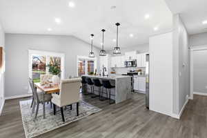 Dining area with recessed lighting, lofted ceiling, and dark wood-type flooring