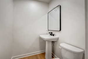Half bath with baseboards and light wood finished floors