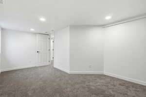 Carpeted spare room featuring recessed lighting and baseboards