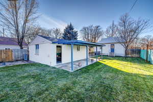 Rear view of house featuring a patio and a fenced backyard