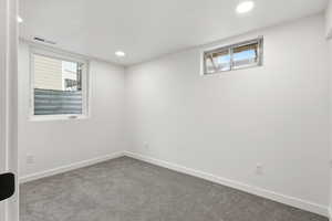 Carpeted empty room with healthy amount of natural light and recessed lighting