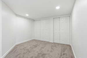 Unfurnished bedroom featuring two closets, carpet, and recessed lighting