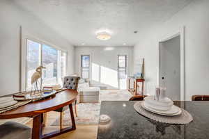 Living room with light wood-style floors and a textured ceiling