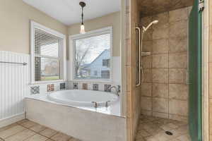 Full bath featuring a bath, a shower stall, and light tile patterned floors