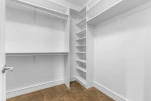 Walk in closet featuring dark carpet