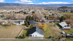Aerial view of property and surrounding area featuring nearby suburban area and mountains