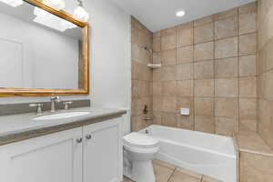 Full bath with  shower combination, vanity, light tile patterned floors, and recessed lighting