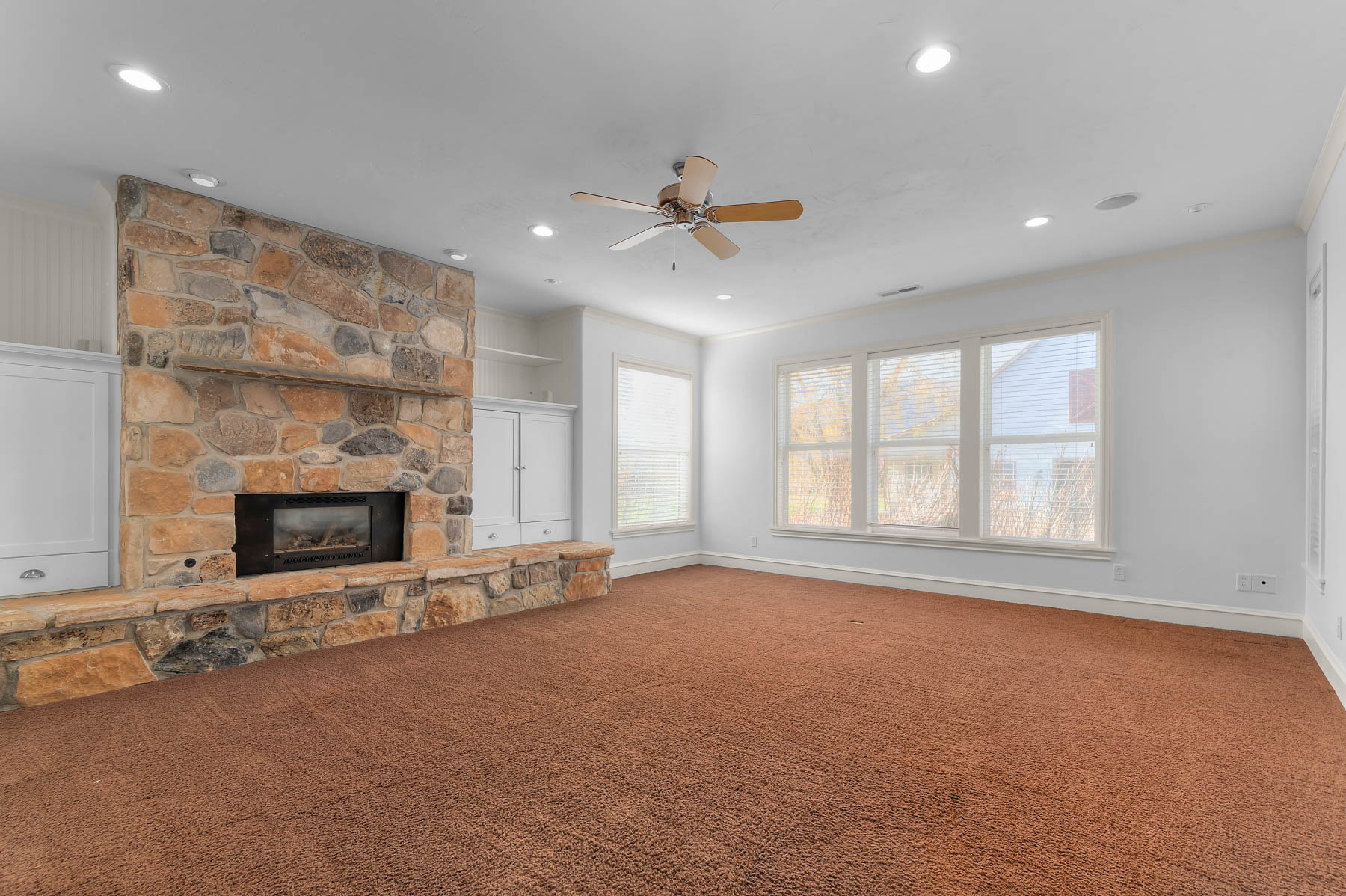 Unfurnished living room with a fireplace, a ceiling fan, carpet floors, recessed lighting, and ornamental molding