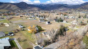 Aerial view of property and surrounding area featuring a mountainous background