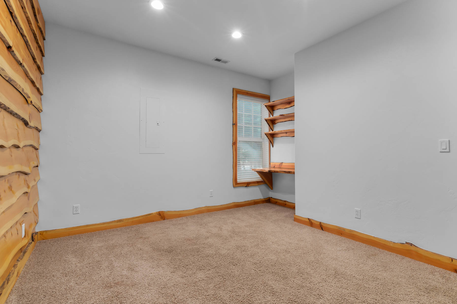 Empty room with light carpet and recessed lighting