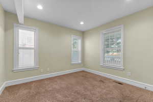 Empty room with healthy amount of natural light, carpet flooring, and recessed lighting