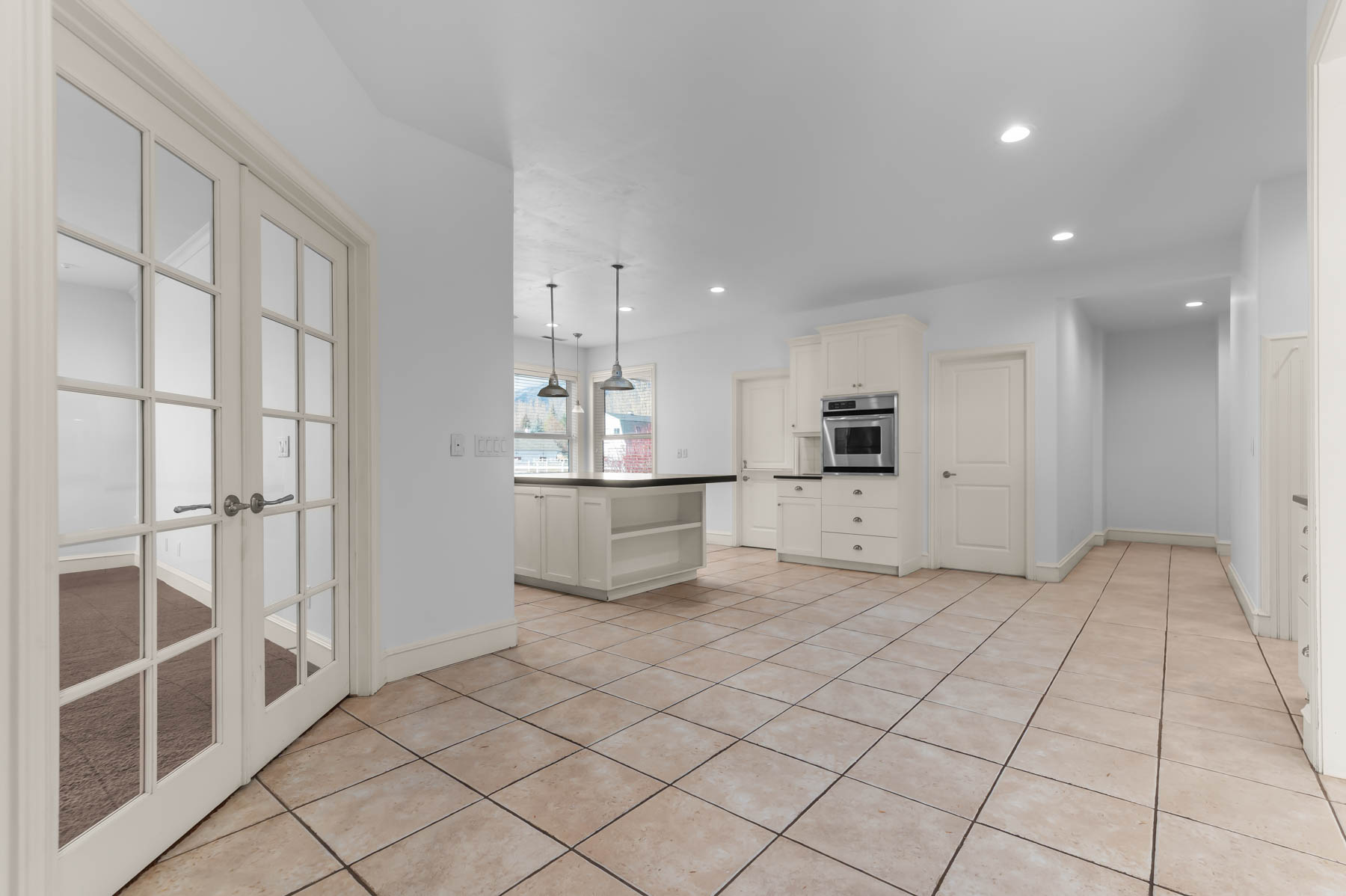 Kitchen featuring dark countertops, hanging light fixtures, open shelves, recessed lighting, and stainless steel oven