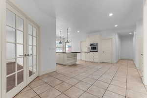 Kitchen featuring dark countertops, hanging light fixtures, open shelves, recessed lighting, and stainless steel oven
