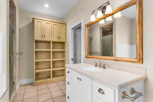 Bathroom with vanity, light tile patterned floors, and a shower stall