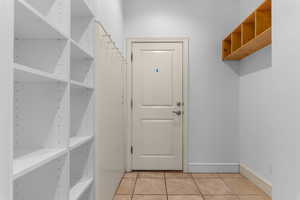 Mudroom featuring light tile patterned flooring and baseboards