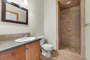 Full bath with vanity, a shower stall, and light tile patterned floors