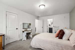 Bedroom with light carpet and ensuite bath