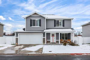Traditional-style home with a porch, a garage, and concrete driveway
