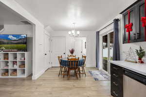 Dining area with a chandelier and light wood-style flooring