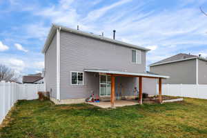 Back of property featuring a fenced backyard and a patio