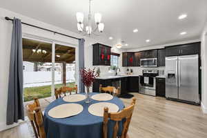 Dining room featuring a chandelier, light wood-style floors, and recessed lighting